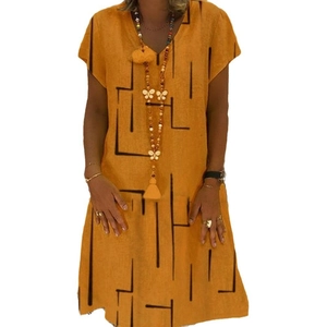 Detail of orange V-neck dress featuring black linear patterns and tassel necklace