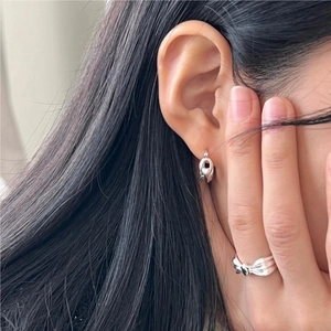 Elegant 925 sterling silver knot earrings and matching ring set worn by a model