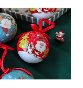 Close-up of red tinplate Christmas ball with Santa illustration and festive red ribbon