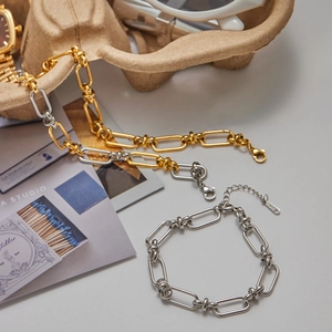 Luxe two-tone stainless steel link bracelet and necklace set with knot accents
