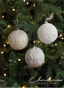 Close-up of 8cm fabric-wrapped Christmas balls with lace texture on a festive tree