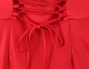 Close-up of elegant lace-up back detail on a red satin fishtail evening gown