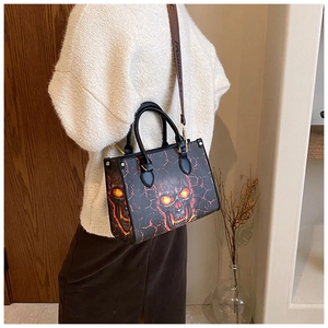 Detail of gothic skull tote bag with red lava pattern and branded fashion wide strap