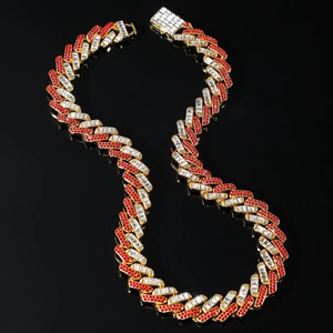 Golden 15mm cuban link chain with red and white zircon diamonds on a black reflective base