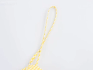 Close-up of yellow and white gingham dress fabric with adjustable shoulder strap detail
