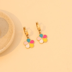 Chic gold hoop earrings with colorful enamel flower pendants on peach background