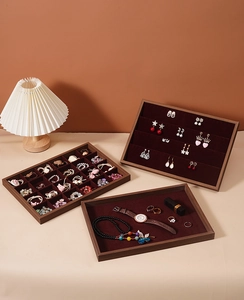 Detail of walnut wood jewelry tray with red velvet lining for rings and watches