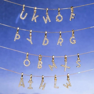 Detail of 26 gold alphabet pendants with sparkling crystals on jewelry display