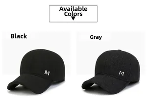 Detail van wollen baseballpetten in zwart en donkergrijs met zilveren metalen M-logo