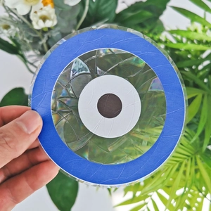 Macro shot of circular blue evil eye suncatcher sticker with a mosaic texture