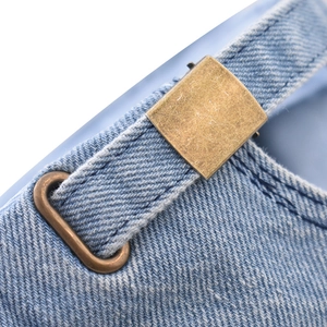 Gros plan sur la boucle en bronze vintage et le denim délavé de la casquette