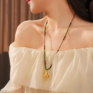 Detail of vintage tiger eye necklace with golden horse pendant and colorful beads