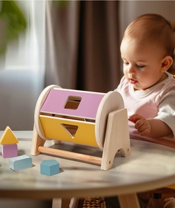 Detail of wooden rolling drum toy with colorful geometric blocks for baby fine motor skills