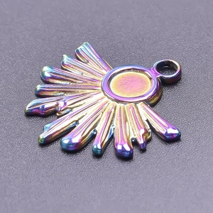Macro shot of a sunburst pendant with vibrant rainbow metallic finish and top loop
