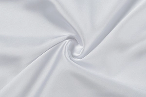 Detailed macro view of white silk satin fabric with smooth texture and elegant drape