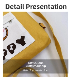 Detail of yellow canvas crossbody bag featuring a white zipper pocket and cute paw print
