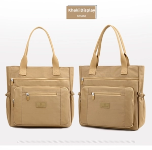 Détail du grand sac cabas en nylon kaki montrant les multiples poches zippées et côtés