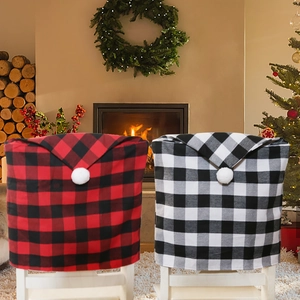 Red and black plaid Christmas chair back covers with white pom-poms for holiday home decor