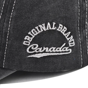 Detailed macro view of white 3D embroidery and contrast stitching on black washed cotton cap