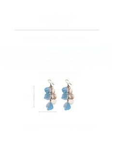 Détail des boucles d'oreilles pétales en verre bleu clair avec disques en cuivre