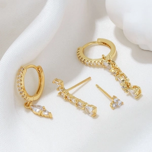 Elegant gold-plated earring set featuring teardrop zirconia pendants on white silk
