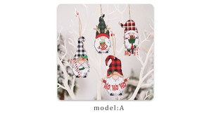 Vue détaillée de quatre gnomes de Noël en bois suspendus à une branche décorative