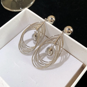 Macro shot of silver tiered oval hoop earrings with metal beads on a jewelry box