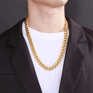 Close-up of 13mm gold Cuban link chain for men worn with a black suit and white shirt