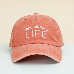 Close-up of coral orange washed cotton baseball cap with white Mom Life embroidery