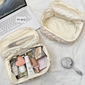 Detail of floral quilted makeup bag with internal mesh pockets and zip closure