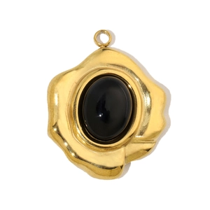 Detail of vintage gold-plated teardrop pendant with a polished black stone inlay