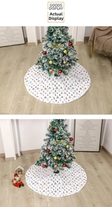 Detail of white velvet Christmas tree skirt with colorful tree patterns and plush texture