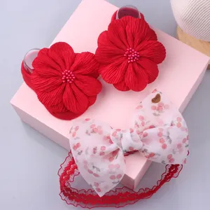 Detail of red floral baby shoes and cherry print bow headband set in a gift box