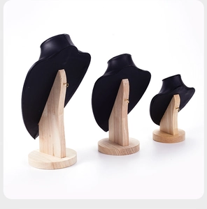 Three sizes of black leather portrait necklace displays with natural wooden stands
