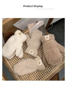 Detailansicht der warmen Teddy-Fleece-Handschuhe mit Bären-Patches auf Korbstuhl