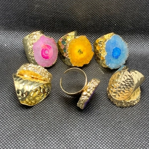 Detalle de anillos ajustables bañados en oro 14K con cristales de colores y textura martillada