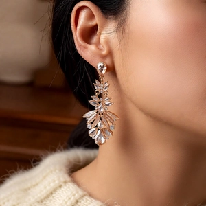 Close-up of vintage feather tassel earrings with sparkling crystals on a model