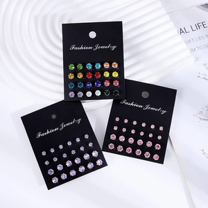 Flat lay of 12 pairs of sparkling cubic zirconia stud earrings in colorful sets