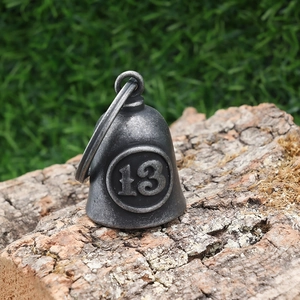 Macro shot of retro stainless steel guardian bell with lucky number 13 on tree bark