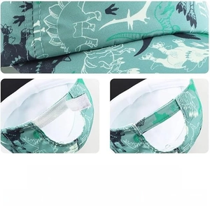 Detail view of adjustable velcro strap and dinosaur print on green children baseball cap