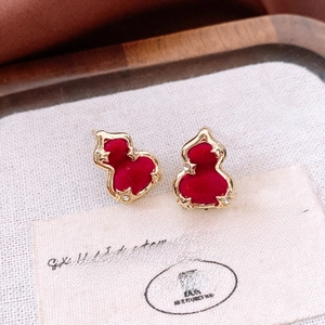 Macro detail of red flocked gourd earring with gold rim and rhinestone star accents