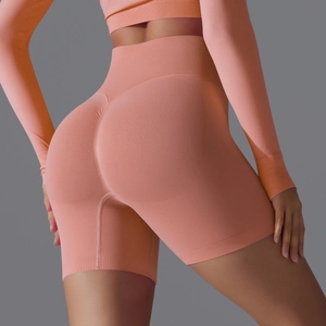 Detail view of peach high-waisted seamless yoga shorts with ruched butt lifting design