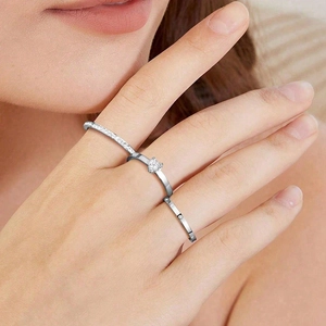Detailed close-up of a silver-tone three-piece ring set with heart zircon on finger