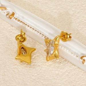 Détail de boucles d'oreilles dorées avec zircon marquise et texture de roche vintage
