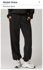 Detail der schwarzen Jogginghose mit hoher Taille, flachem Kordelzug und Rippbündchen