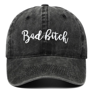 Detailed view of white letter embroidery on washed black denim baseball cap