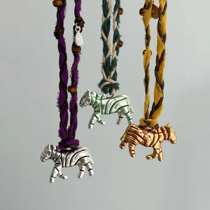 Gros plan du pendentif zèbre avec perles colorées et cordon en coton tissé à la main