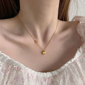 Elegant gold heart pendant necklace featuring a solid 3D heart and small hollow heart charm