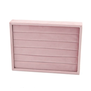 Detail of pink velvet jewelry tray with multiple slots for rings and earrings