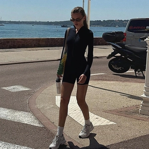 Detail of female black long sleeve bodysuit with zipper and slim fit athletic design